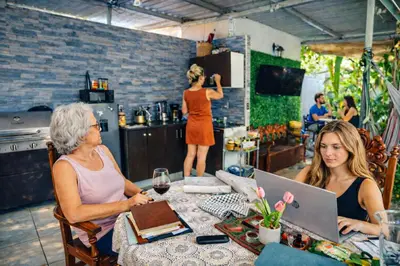 two women sitting at a table with a laptop at Habitación Deluxe Aire - Villa Valle Campo in Nahuizalco