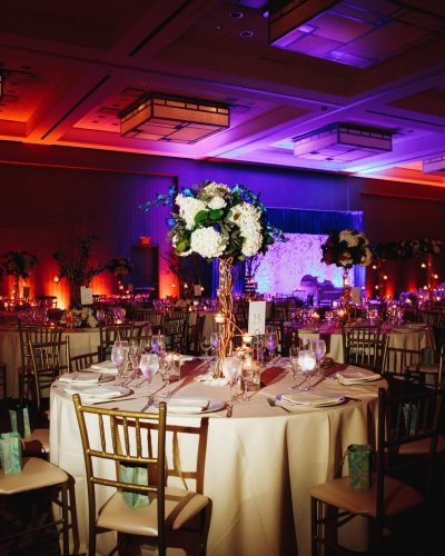 Decorated banquet hall with served round table with hydrangea centerpiece and chiavari chairs